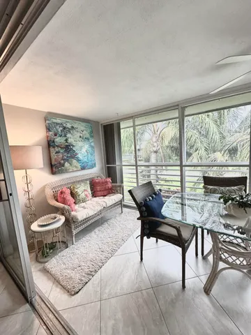 a living room with furniture and a floor to ceiling window