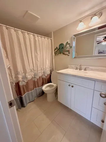 a bathroom with a double vanity sink toilet and shower