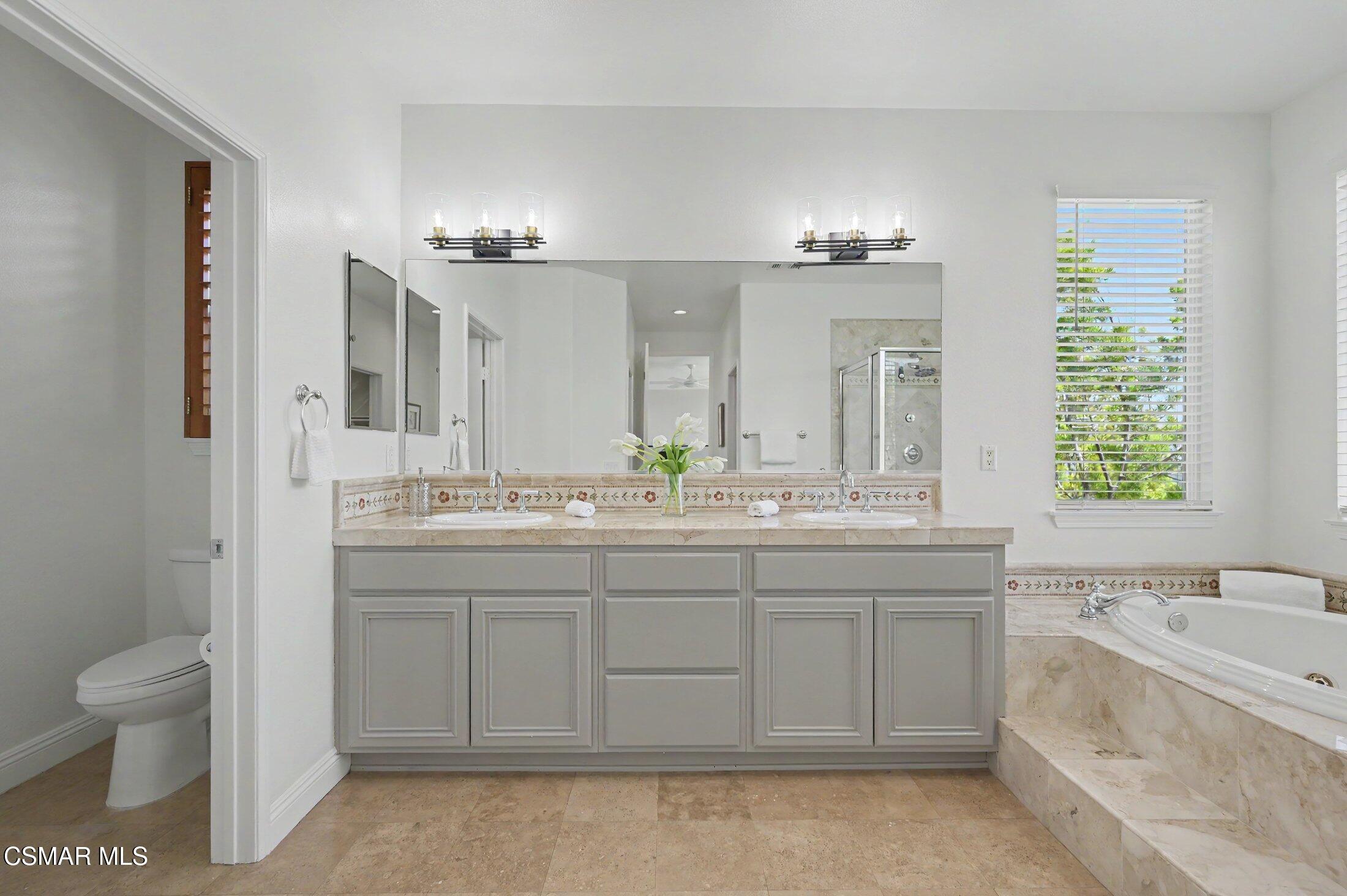 20800 Sardinia Way Porter Ranch, CA 91326 - Photo 30 of 57 a bathroom with a granite countertop sink a toilet and a bathtub