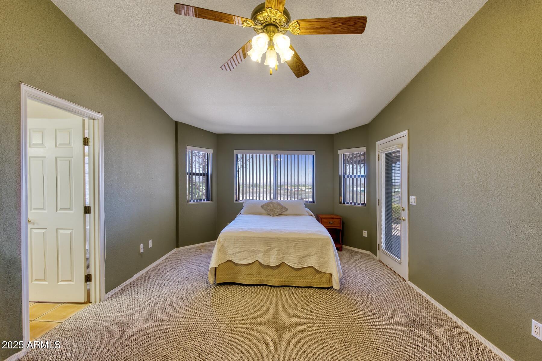2290 North Ranch Trail Huachuca City, AZ 85616 - Photo 17 of 28 a spacious bedroom with a bed and a chandelier