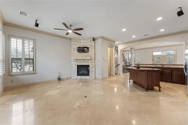 a view of an empty room with a kitchen and a window