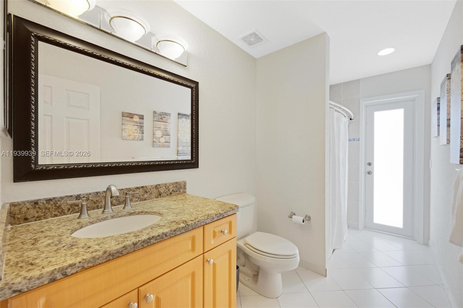 12851 Luray Road Southwest Ranches, FL 33330 - Photo 13 of 43 a bathroom with a granite countertop sink toilet and a mirror