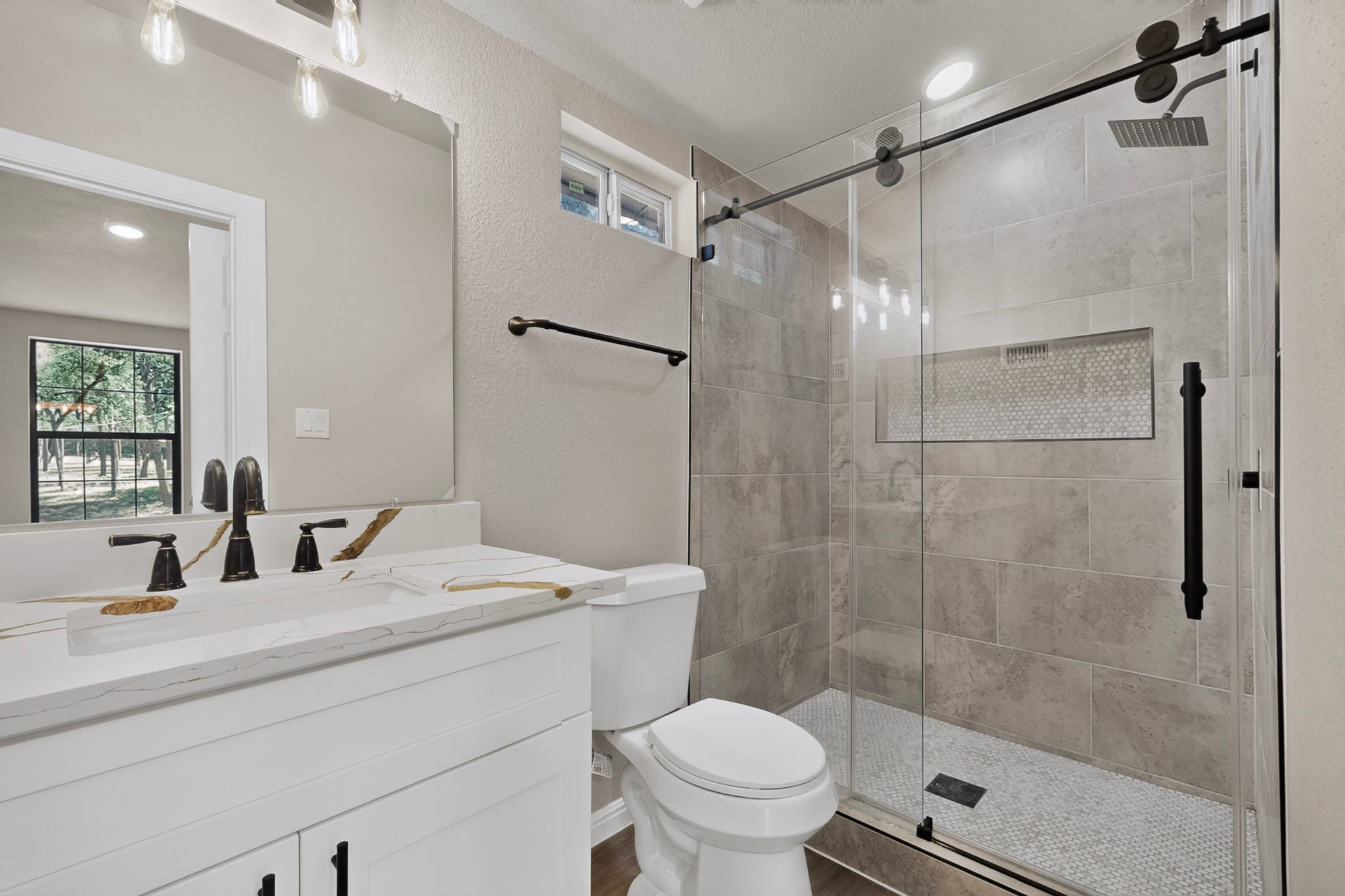 158 Fealy Road Red Rock, TX 78662 - Photo 26 of 40 A modern bathroom features a glass-enclosed walk-in shower with contemporary tile work and fixtures.
