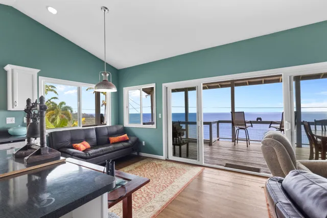 a living room with furniture a rug and a floor to ceiling window