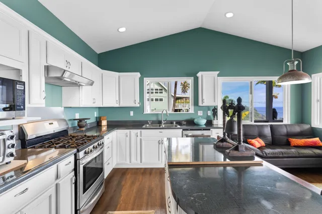 a kitchen with stainless steel appliances granite countertop a sink dishwasher stove and refrigerator with wooden floor