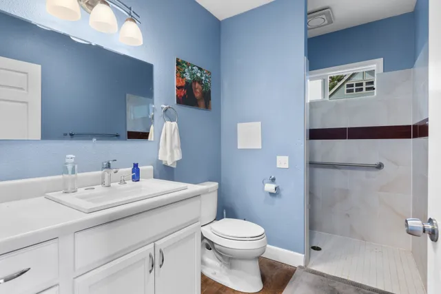 a bathroom with a sink mirror vanity and toilet