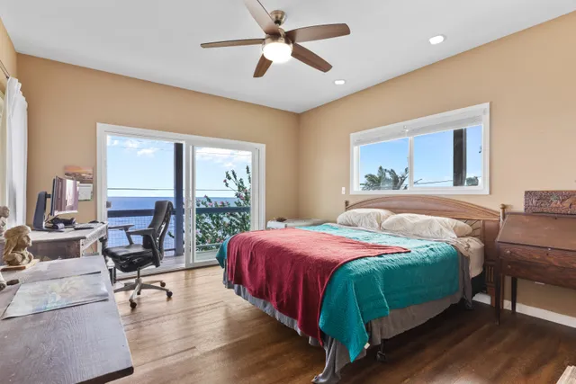 a bedroom with a bed a large window with table and chairs