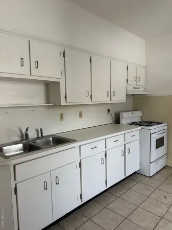 a kitchen with white cabinets and white appliances