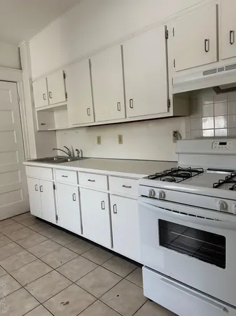 a kitchen with granite countertop white cabinets and white appliances