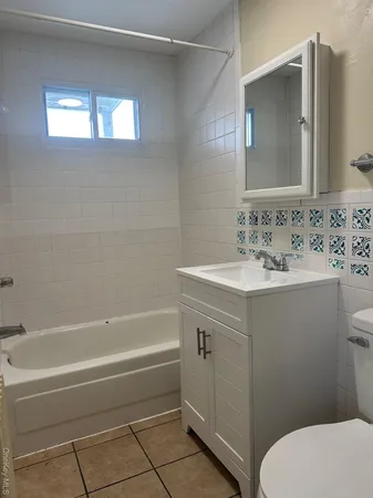 a bathroom with a sink vanity mirror and toilet