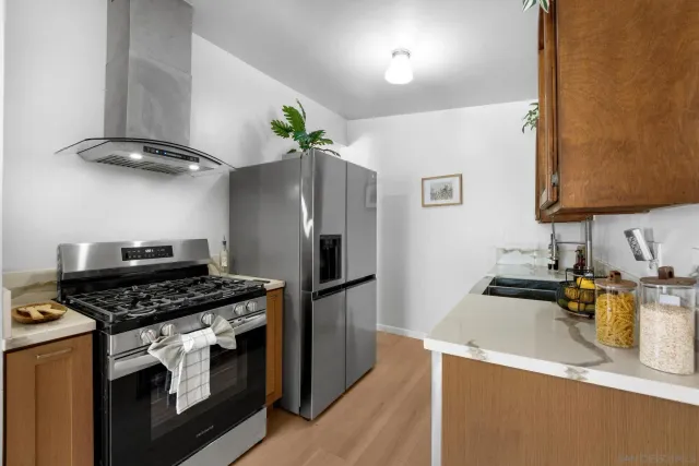 a kitchen with stainless steel appliances granite countertop a refrigerator and a stove