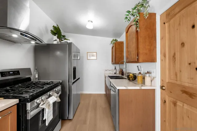 a kitchen with stainless steel appliances granite countertop a stove a sink and a refrigerator