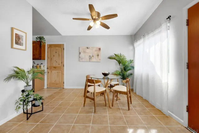 a dining room with furniture and a potted plant