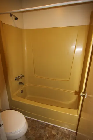 a bathroom with a toilet and a shower
