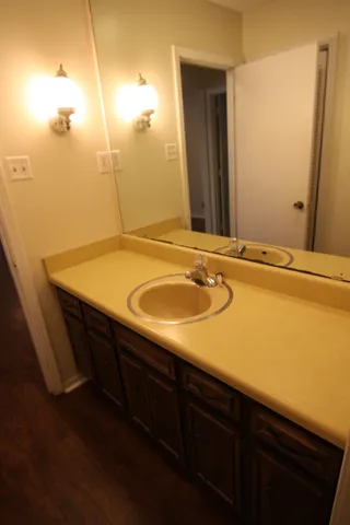 a bathroom with a granite countertop sink and a mirror