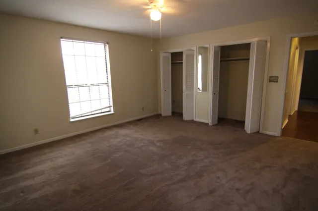 an empty room with windows and closet