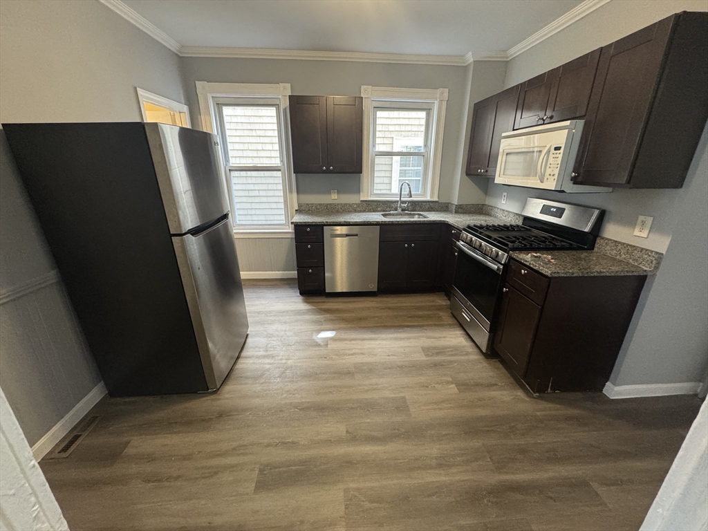 18 Chase Street, Unit 1 Boston, MA 02125 - Photo 3 of 10 a kitchen with stainless steel appliances granite countertop a refrigerator stove and sink