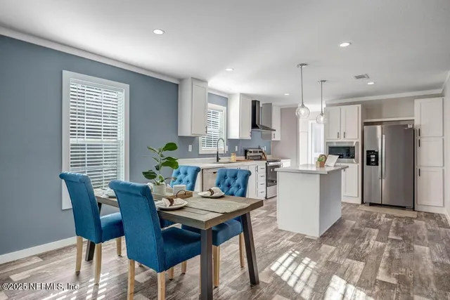 a kitchen with refrigerator and chairs