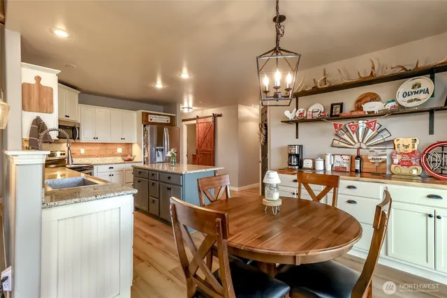 a view of a dining room with furniture a chandelier and large window
