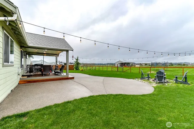a yard with lots of green space and mountain view in back