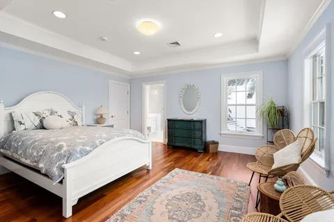 a spacious bedroom with a bed and a chair