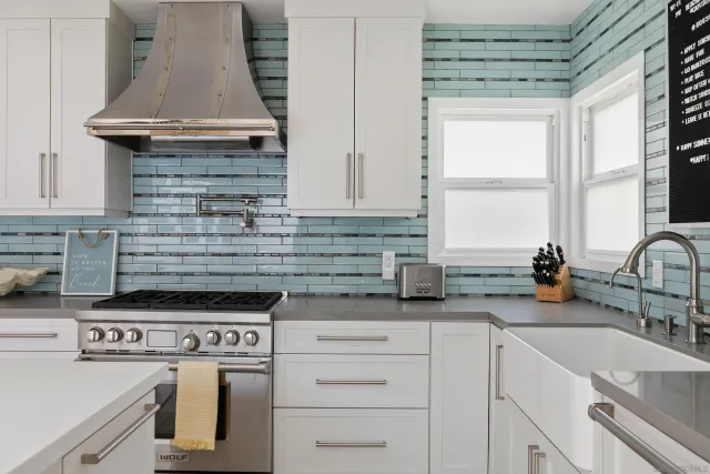 a kitchen with granite countertop a stove sink and cabinets