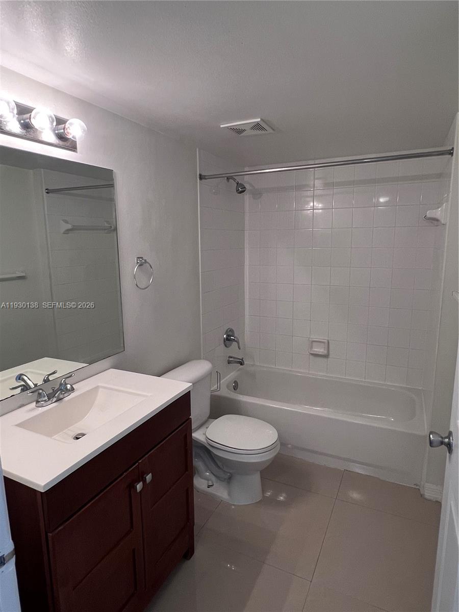 5061 Wiles Road, Unit 102 Coconut Creek, FL 33073 - Photo 12 of 14 a bathroom with a sink a toilet and shower
