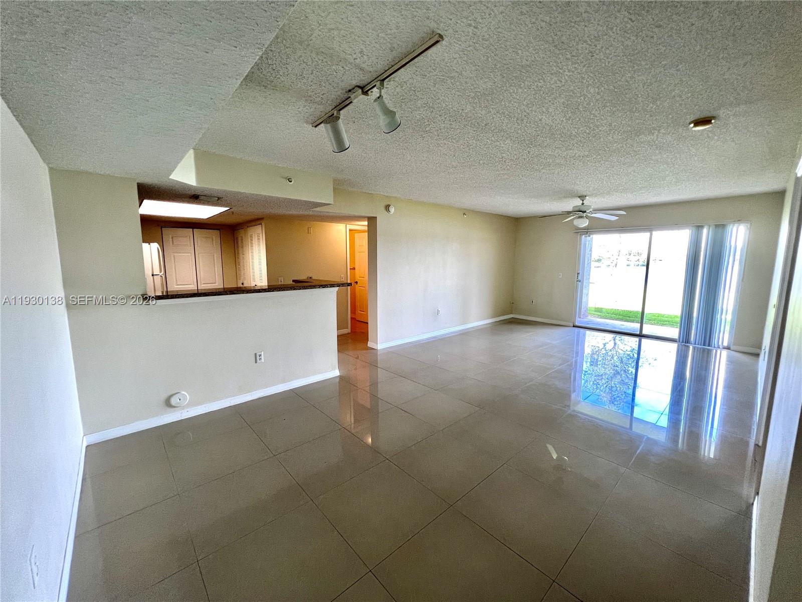 5061 Wiles Road, Unit 102 Coconut Creek, FL 33073 - Photo 2 of 14 wooden floor in an empty room with a window
