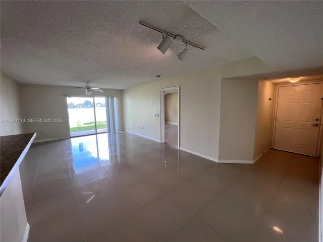 an empty room with windows and ceiling fan