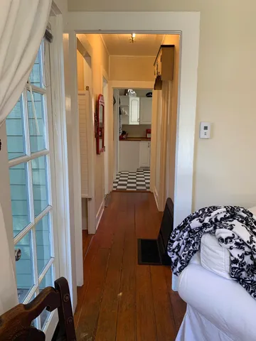 a view of a hallway with wooden floor and windows