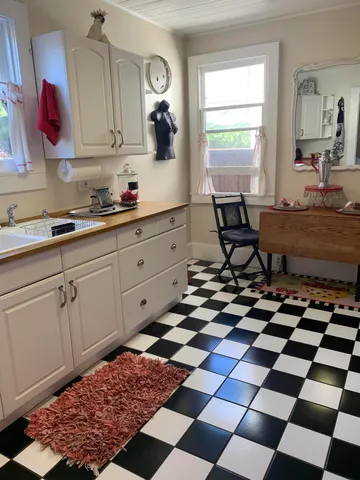 a kitchen with a checkered floor and white cabinets