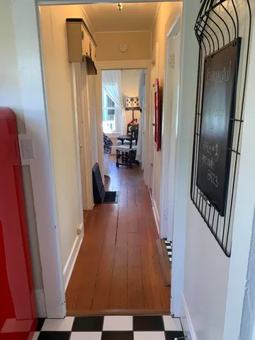 a view of a hallway with wooden floor and stairs