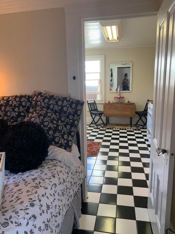 a bedroom with a bed and a black white checkered floor