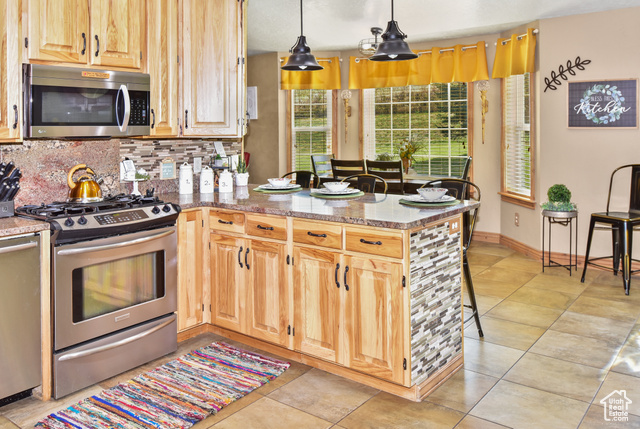 1500 Fish Creek Road Bancroft, ID 83217 - Photo 3 of 45 Kitchen with appliances with stainless steel finishes, light brown cabinetry, a peninsula, and backsplash