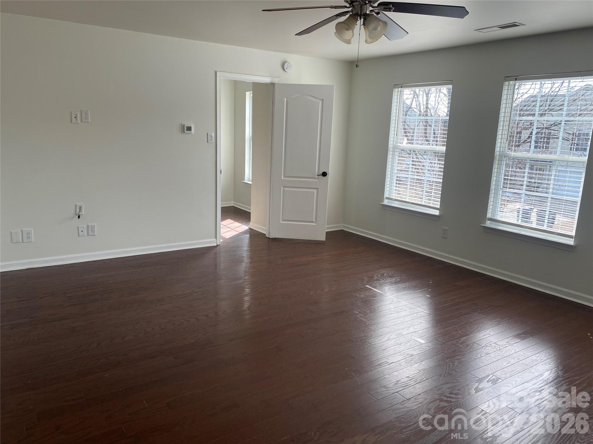 2054 Durand Road Fort Mill, SC 29715 - Photo 24 of 29 an empty room with wooden floor and windows with curtains