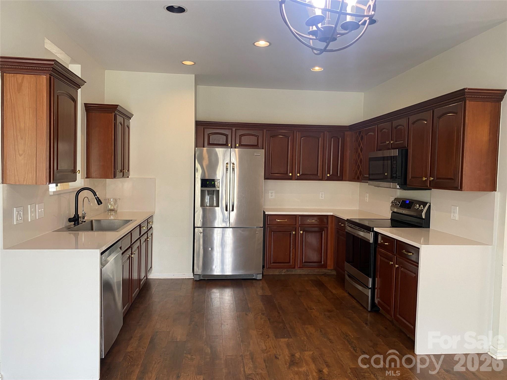 2054 Durand Road Fort Mill, SC 29715 - Photo 8 of 30 a kitchen with stainless steel appliances granite countertop a refrigerator a sink dishwasher a stove with wooden cabinets and floor