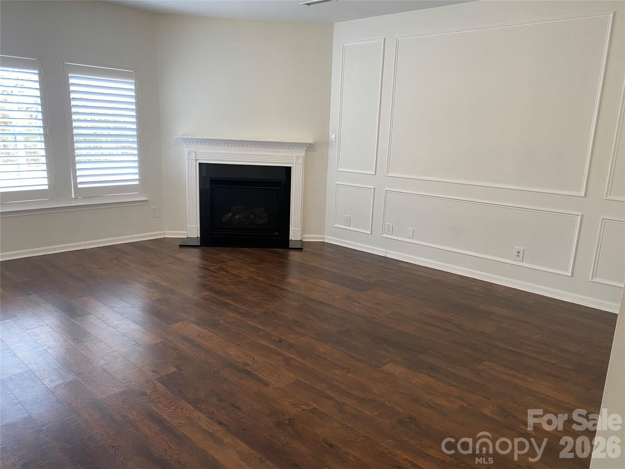 2054 Durand Road Fort Mill, SC 29715 - Photo 10 of 30 an empty room with wooden floor fireplace and windows