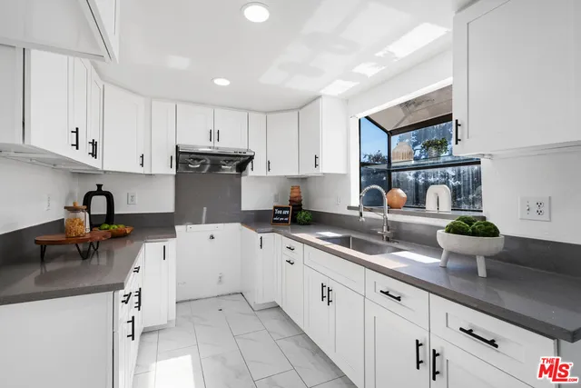 a kitchen with a sink dishwasher stove and cabinets