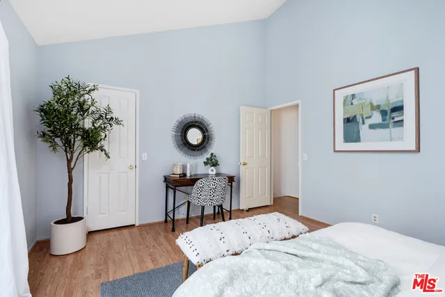 a bedroom with a bed and a potted plant