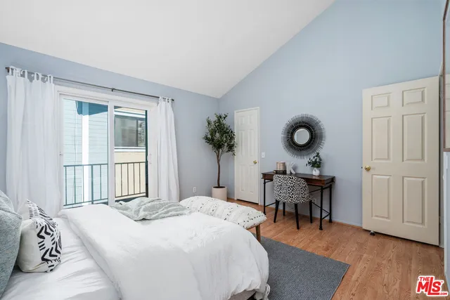 a bedroom with a bed and a table in it with wooden floor