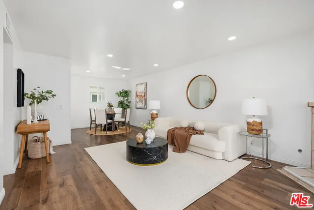 a living room with furniture a mirror and a potted plant