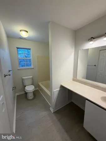 a bathroom with a toilet a sink and a mirror