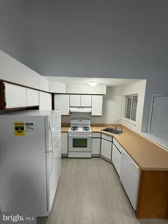 a kitchen with stainless steel appliances a refrigerator a sink and white stove