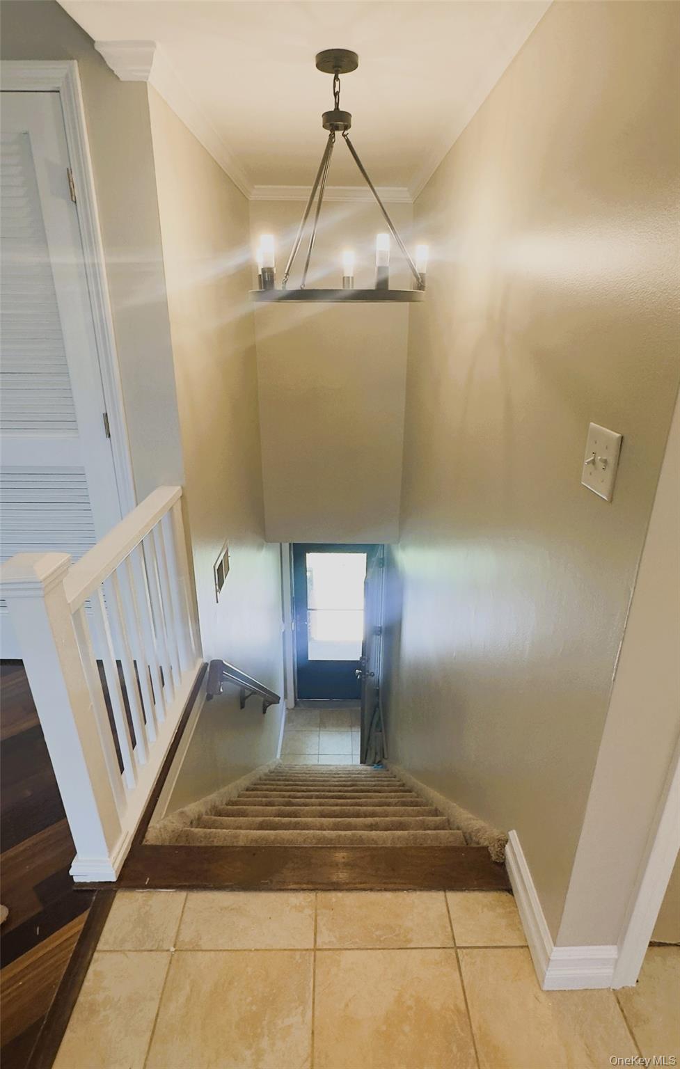 26 Cooper, Unit 603 Poughkeepsie, NY 12603 - Photo 2 of 16 Top view of stairs case, chandelier, wooden railing, crown molding.