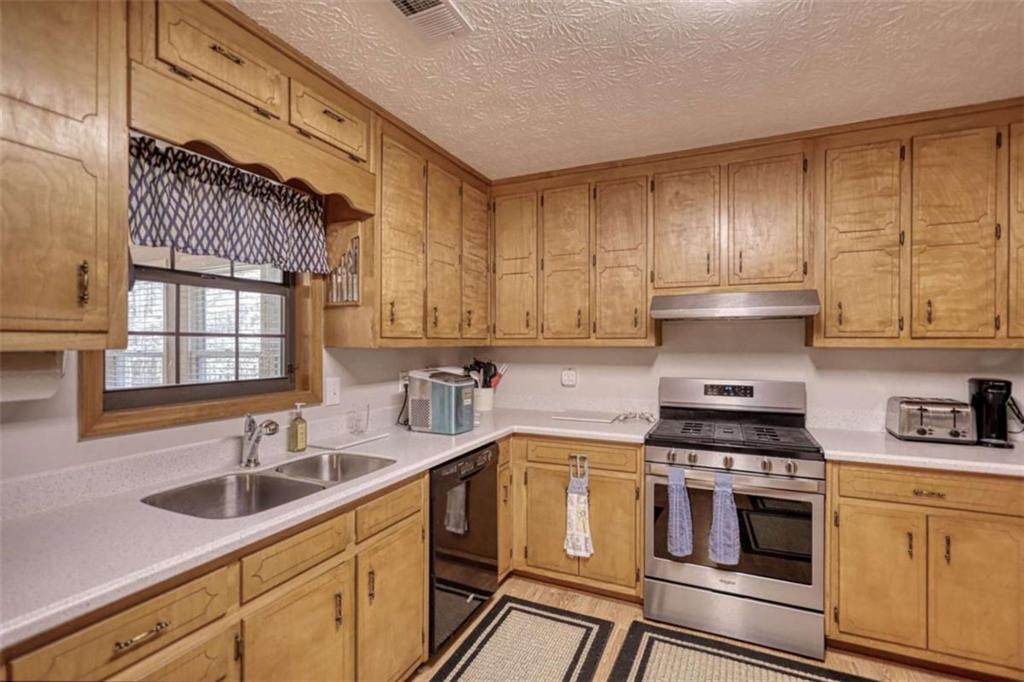 2740 Dennard Road Northeast Conyers, GA 30013 - Photo 13 of 51 a kitchen with stainless steel appliances a sink cabinets and a window