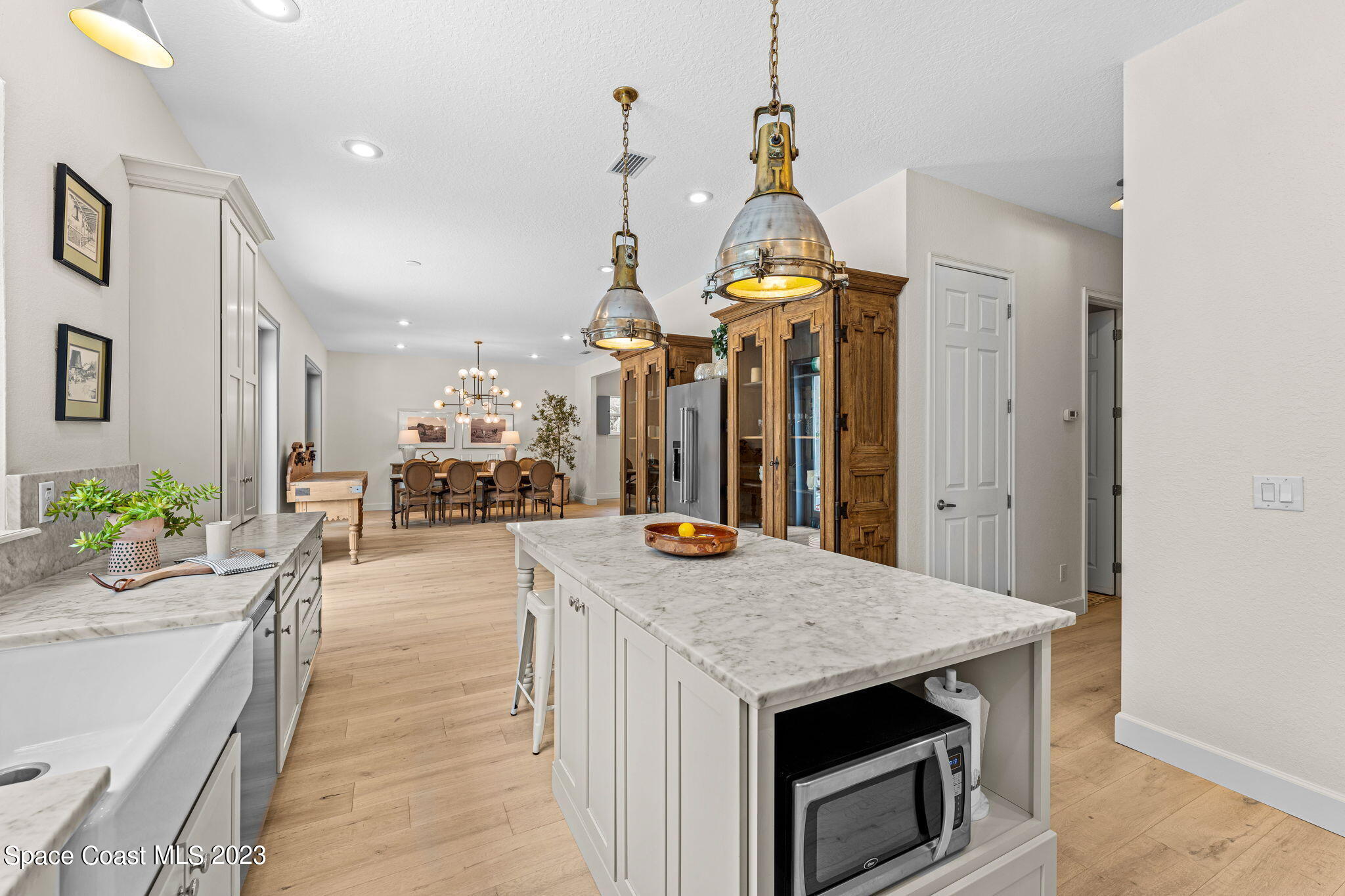 5595 Willoughby Drive Melbourne, FL 32934 - Photo 11 of 40 a kitchen view with stainless steel appliances granite countertop a sink a stove and a wooden floors