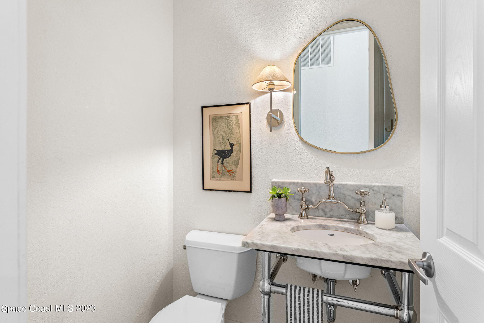 5595 Willoughby Drive Melbourne, FL 32934 - Photo 12 of 40 a bathroom with a toilet a sink and mirror