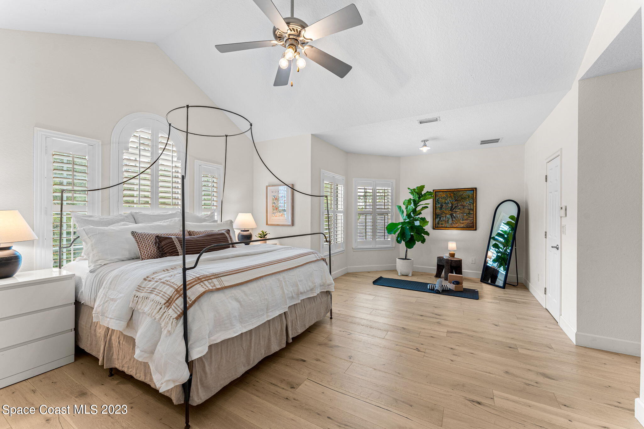 5595 Willoughby Drive Melbourne, FL 32934 - Photo 14 of 40 a bedroom with a bed a chandelier and a window