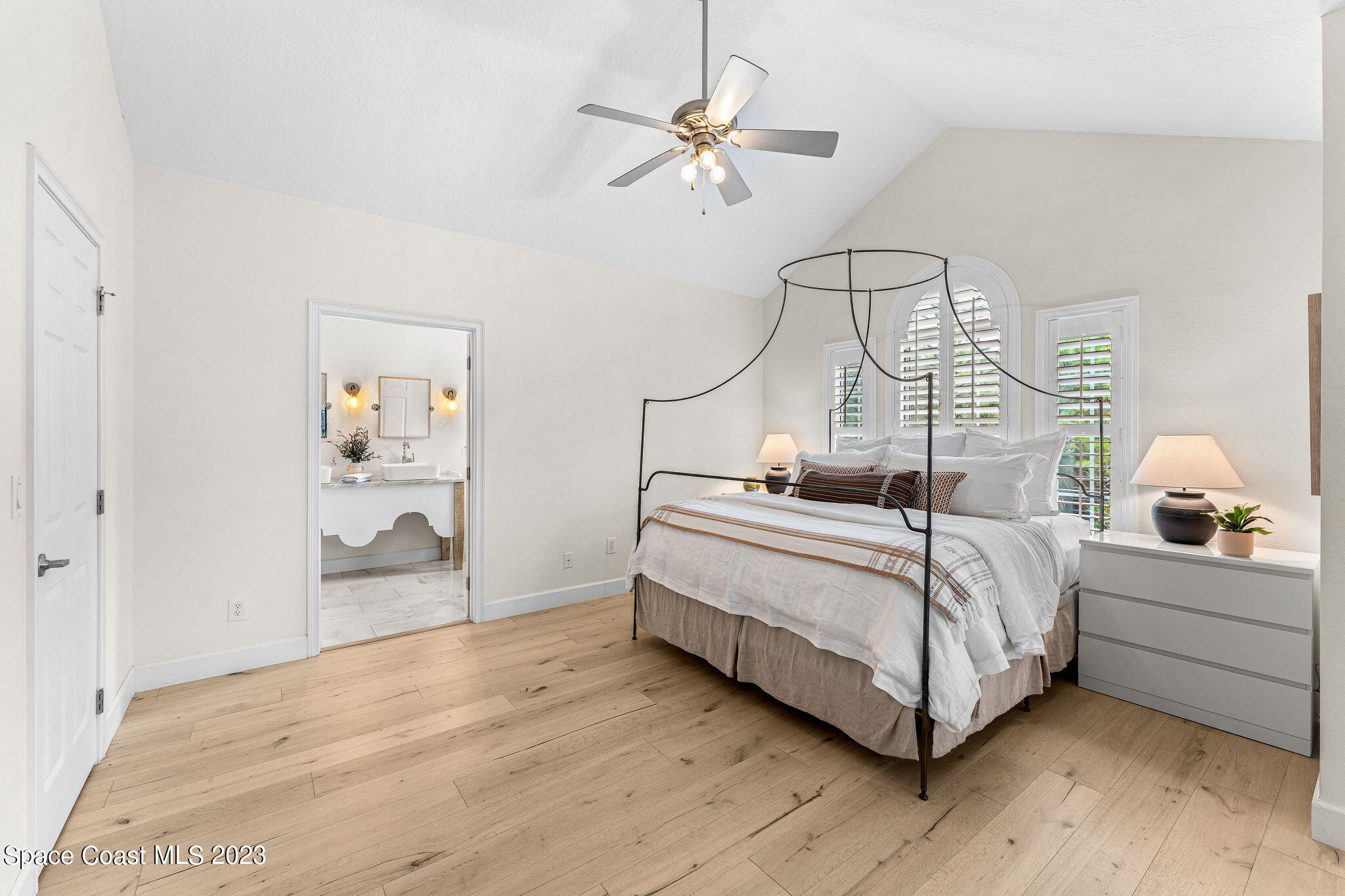 5595 Willoughby Drive Melbourne, FL 32934 - Photo 15 of 40 a bedroom with a bed and a chandelier