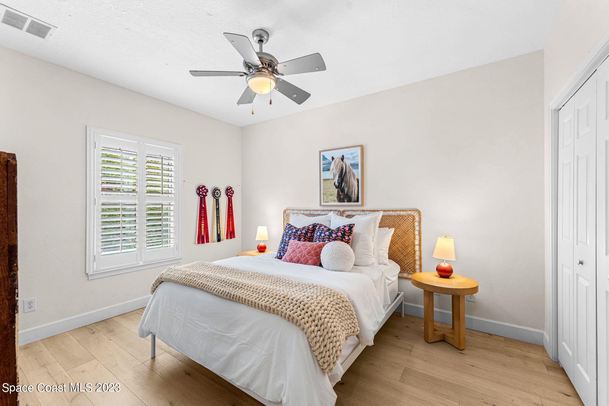 5595 Willoughby Drive Melbourne, FL 32934 - Photo 18 of 40 a bedroom with a bed and a chandelier